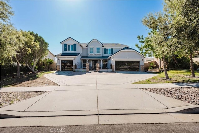 view of front of house with an attached garage, concrete driveway, and stucco siding