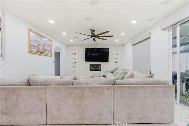 living room featuring marble finish floor, arched walkways, a ceiling fan, and recessed lighting