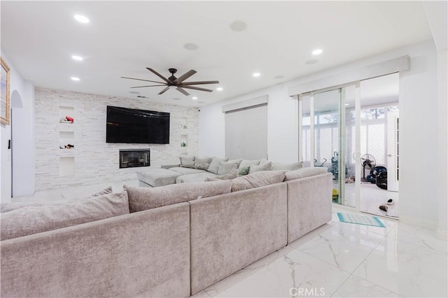 living area featuring a ceiling fan, recessed lighting, a large fireplace, and marble finish floor