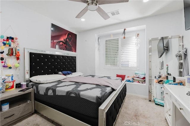 bedroom with light carpet, ceiling fan, visible vents, and baseboards