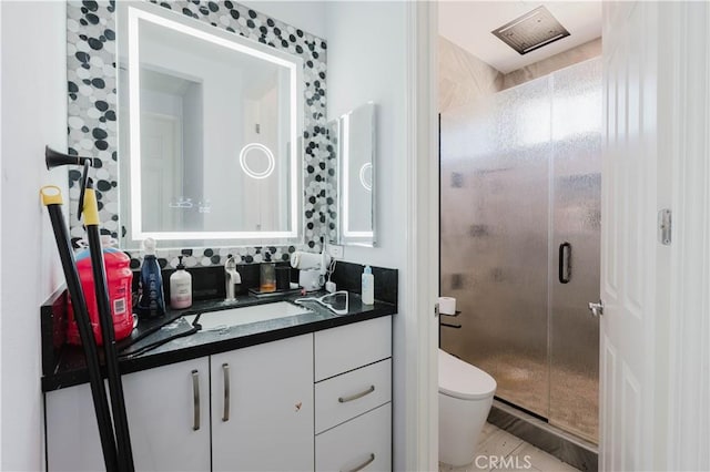 bathroom with a stall shower, vanity, and toilet