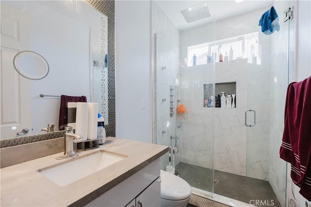 bathroom with a stall shower, vanity, and toilet