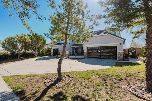 view of front of home featuring a garage, stone siding, driveway, a gate, and stucco siding