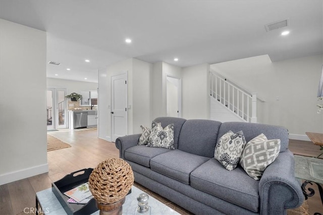 living room with recessed lighting, wood finished floors, visible vents, baseboards, and stairway