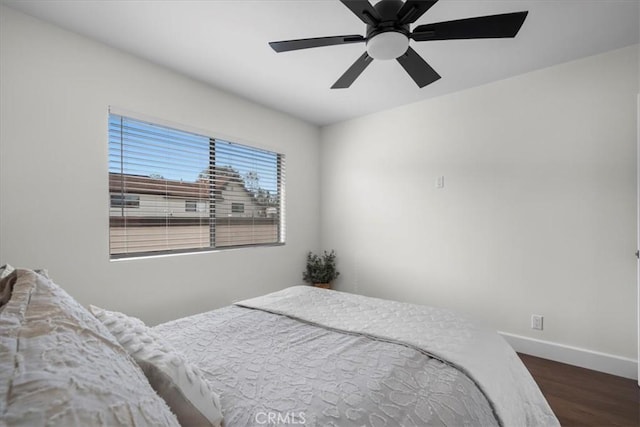 bedroom featuring ceiling fan, baseboards, and wood finished floors