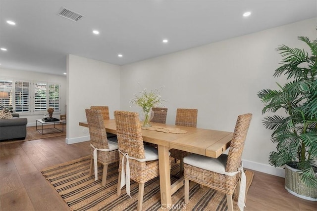 dining area with baseboards, visible vents, wood finished floors, and recessed lighting