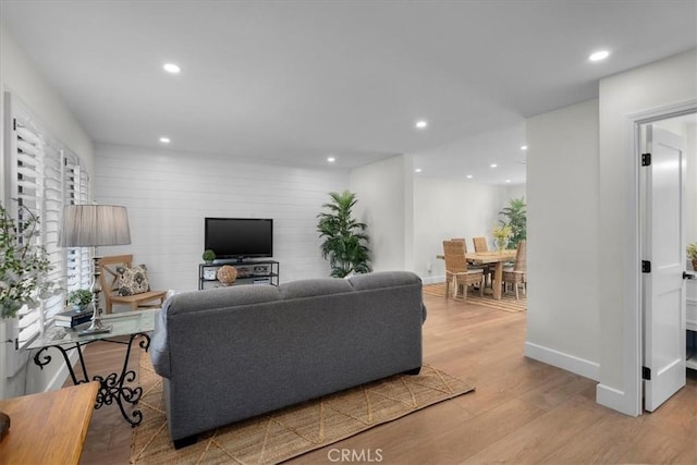 living room featuring baseboards, light wood-style flooring, and recessed lighting