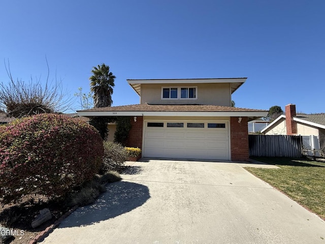 view of front of property with driveway, brick siding, an attached garage, and fence