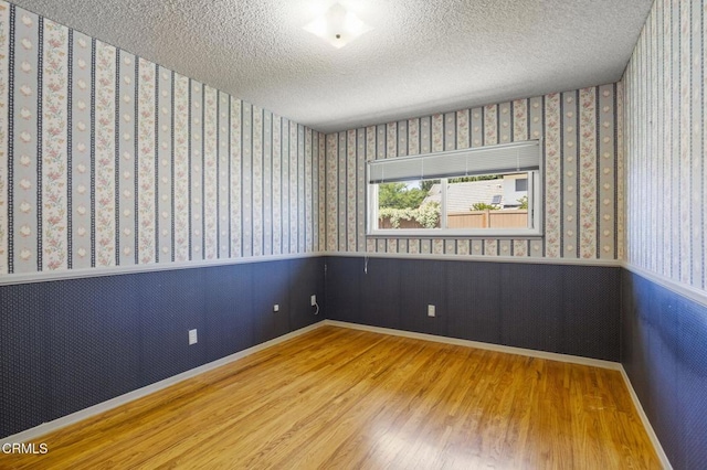 205 Bluefield Ave, Newbury Park, CA 91320 - spare room featuring wood finished floors, wallpapered walls, wainscoting, a textured ceiling, and baseboards