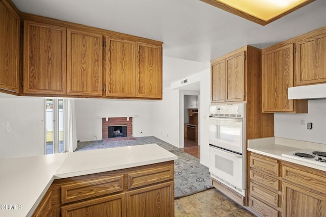 205 Bluefield Ave, Newbury Park, CA 91320 - kitchen with white appliances, light countertops, under cabinet range hood, and brown cabinetry
