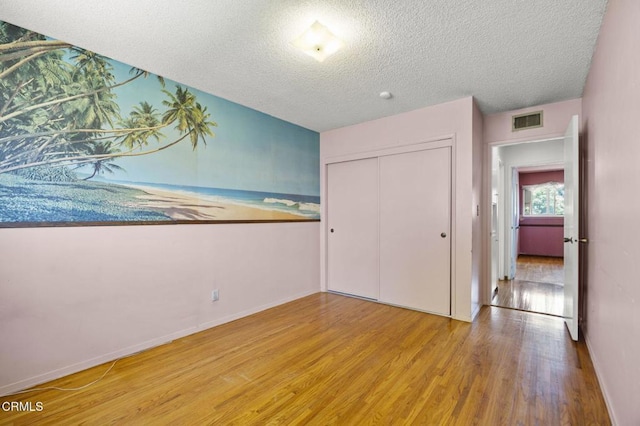 205 Bluefield Ave, Newbury Park, CA 91320 - unfurnished bedroom featuring light wood finished floors, a textured ceiling, baseboards, and a closet
