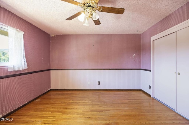 205 Bluefield Ave, Newbury Park, CA 91320 - unfurnished bedroom with light wood-style flooring, wainscoting, a closet, a textured ceiling, and ceiling fan