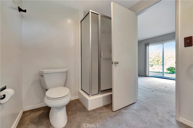 bathroom featuring toilet, baseboards, and a stall shower