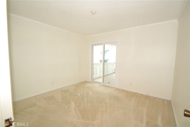 empty room with ornamental molding, carpet, and baseboards