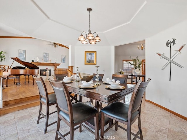 dining area featuring lofted ceiling, baseboards, a tray ceiling, and ceiling fan with notable chandelier