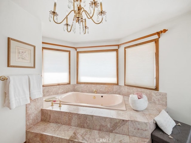 bathroom with a garden tub and an inviting chandelier