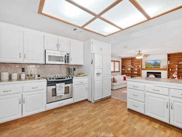 kitchen with light wood finished floors, light countertops, visible vents, appliances with stainless steel finishes, and white cabinets