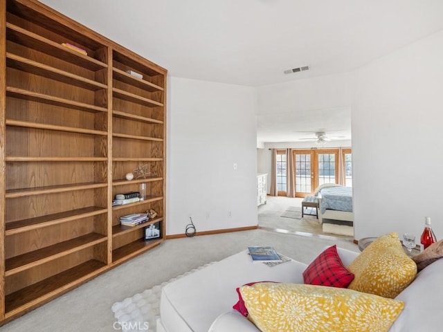 carpeted living area featuring french doors, visible vents, and baseboards