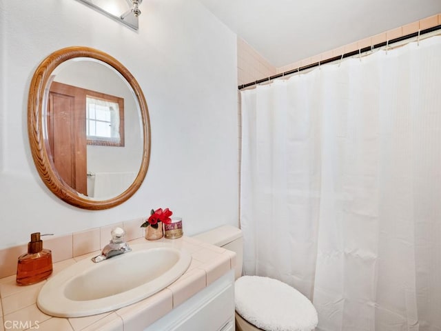 full bath featuring toilet, curtained shower, and vanity