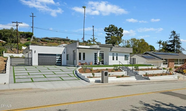 view of front of property featuring stucco siding, a garage, and fence