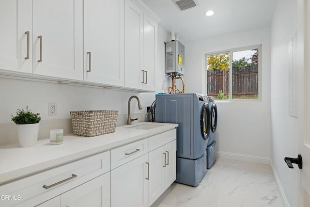 laundry room featuring visible vents, water heater, a sink, marble finish floor, and washer and clothes dryer