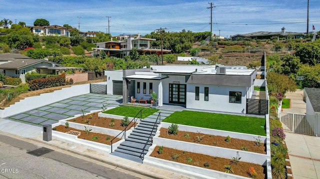 modern home with french doors, a front lawn, a garage, and fence