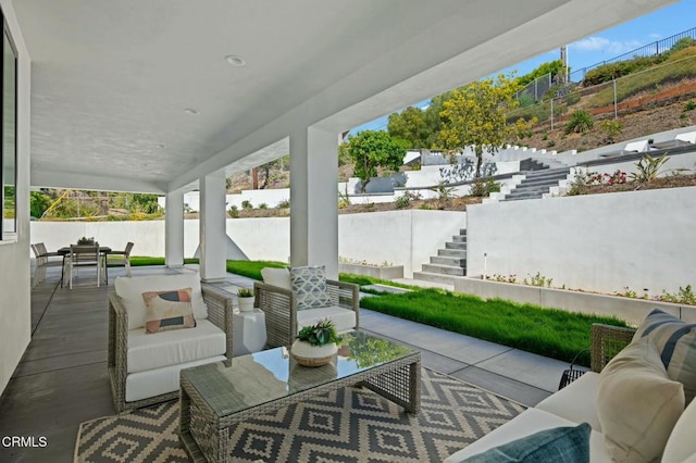 view of patio / terrace featuring stairway, an outdoor living space, outdoor dining area, and fence