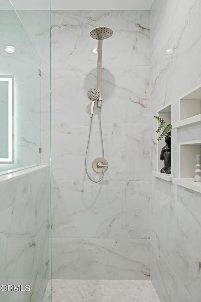 bathroom featuring a marble finish shower