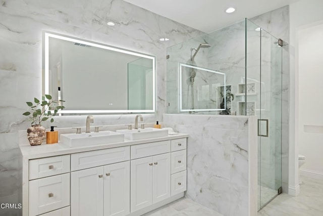 bathroom with a marble finish shower, marble finish floor, tile walls, and a sink