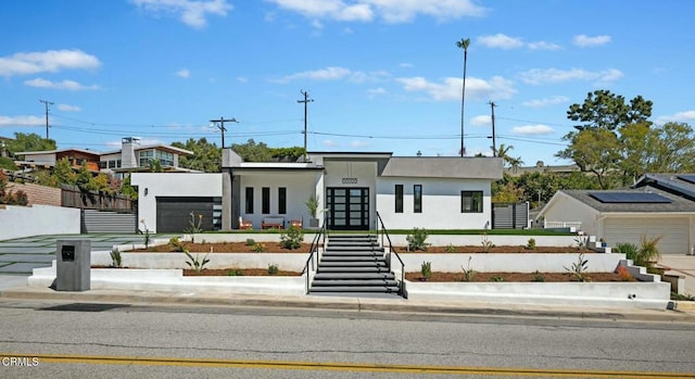 view of front of house featuring stairway, fence, french doors, and stucco siding