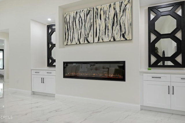 details with a glass covered fireplace, recessed lighting, and baseboards