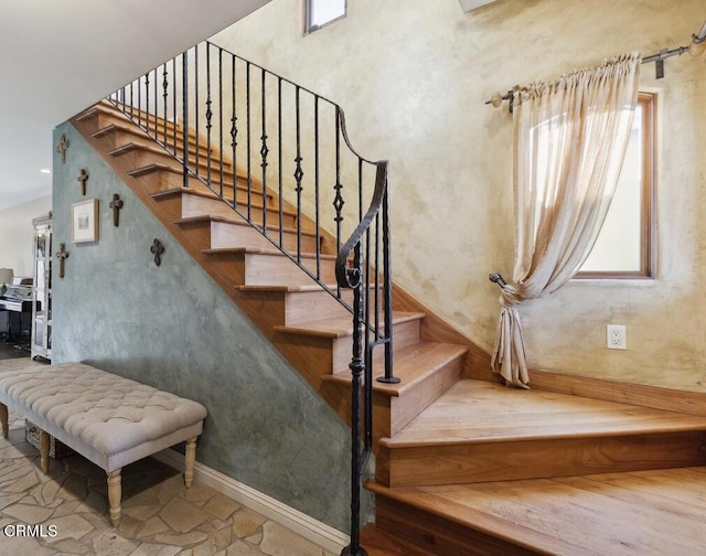 staircase with baseboards and stone finish floor