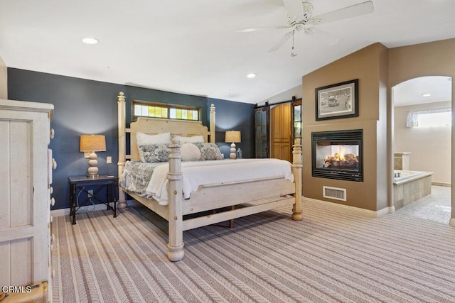 bedroom featuring a barn door, carpet, visible vents, and baseboards