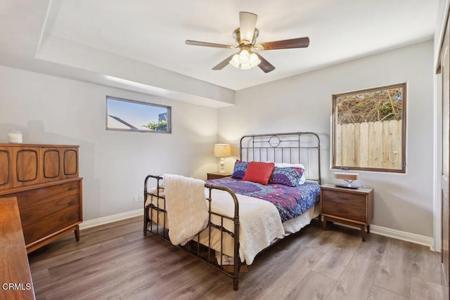 bedroom featuring ceiling fan, wood finished floors, and baseboards