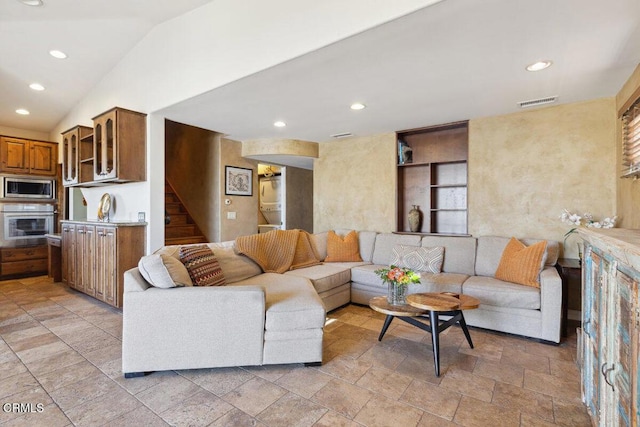 living room with stone finish flooring, stairs, vaulted ceiling, and recessed lighting