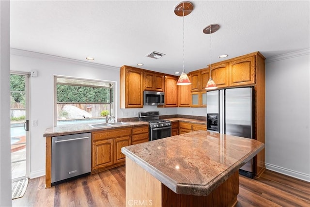 kitchen with dark wood-style floors, brown cabinets, stainless steel appliances, ornamental molding, and a sink