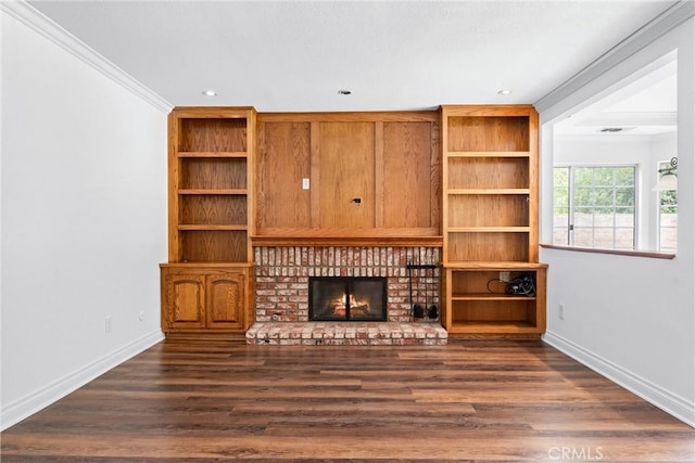 unfurnished living room with dark wood-style floors, a brick fireplace, baseboards, and crown molding