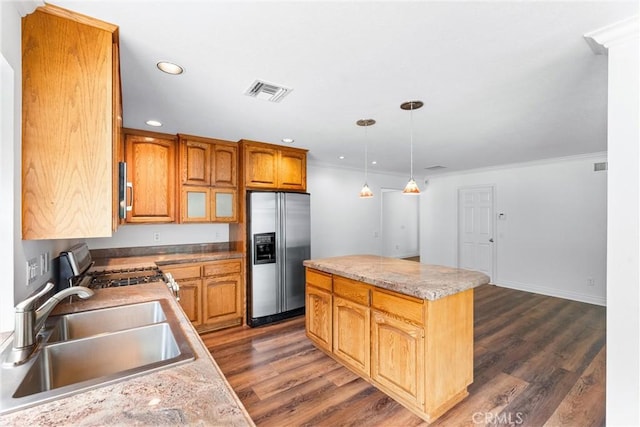 kitchen featuring dark wood-style floors, a center island, visible vents, appliances with stainless steel finishes, and a sink