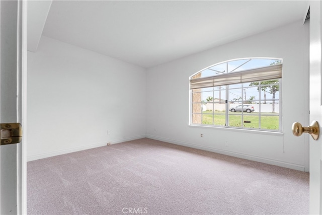 spare room featuring carpet and baseboards