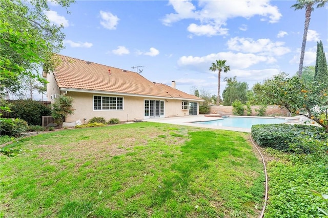 rear view of house featuring stucco siding, a patio area, french doors, and a yard