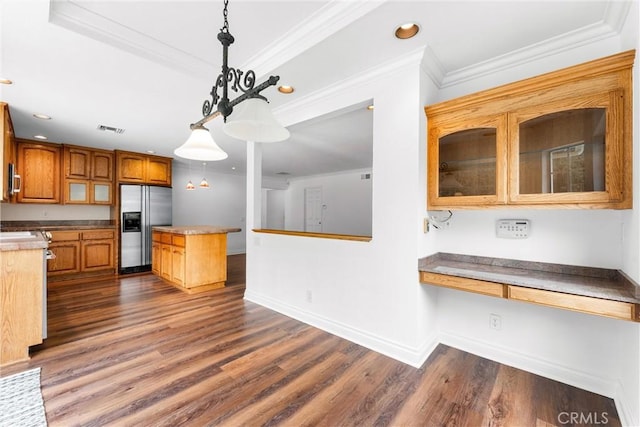 kitchen featuring visible vents, dark wood-style floors, ornamental molding, stainless steel refrigerator with ice dispenser, and built in desk