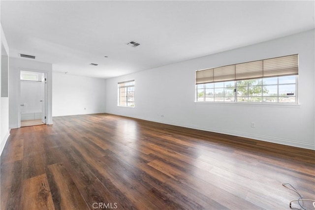 spare room with visible vents, baseboards, and wood finished floors