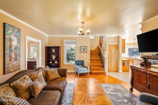 living room with light wood-style floors, stairway, a chandelier, and crown molding