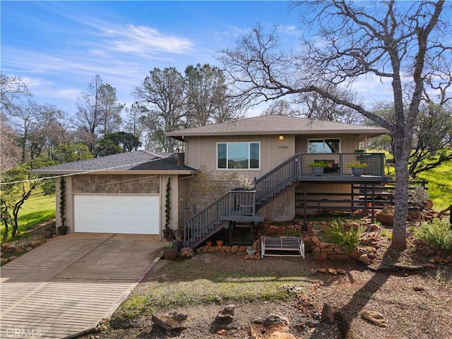 view of front of home featuring driveway, an attached garage, stairs, and roof with shingles