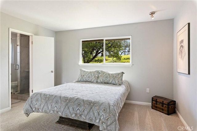 carpeted bedroom featuring baseboards and ensuite bathroom