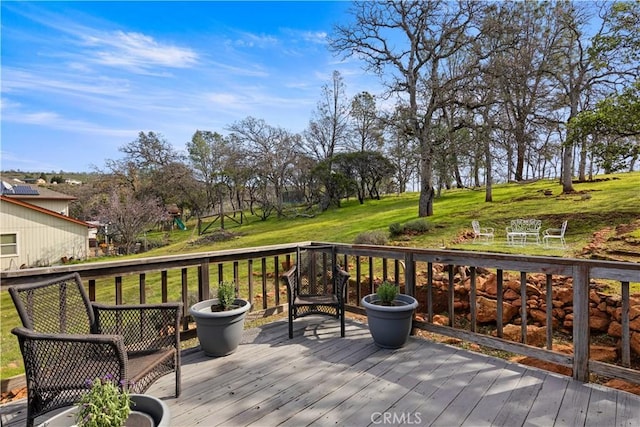 wooden deck featuring a lawn