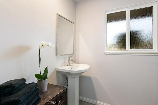 bathroom with a sink and baseboards