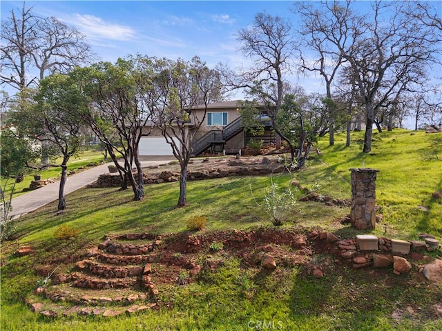 view of yard with driveway and stairway