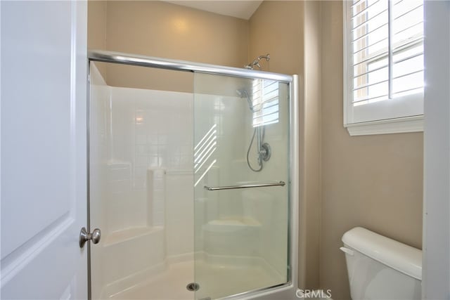 bathroom with a shower stall and toilet