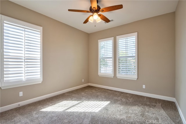 unfurnished room featuring baseboards, a ceiling fan, carpet flooring, and visible vents